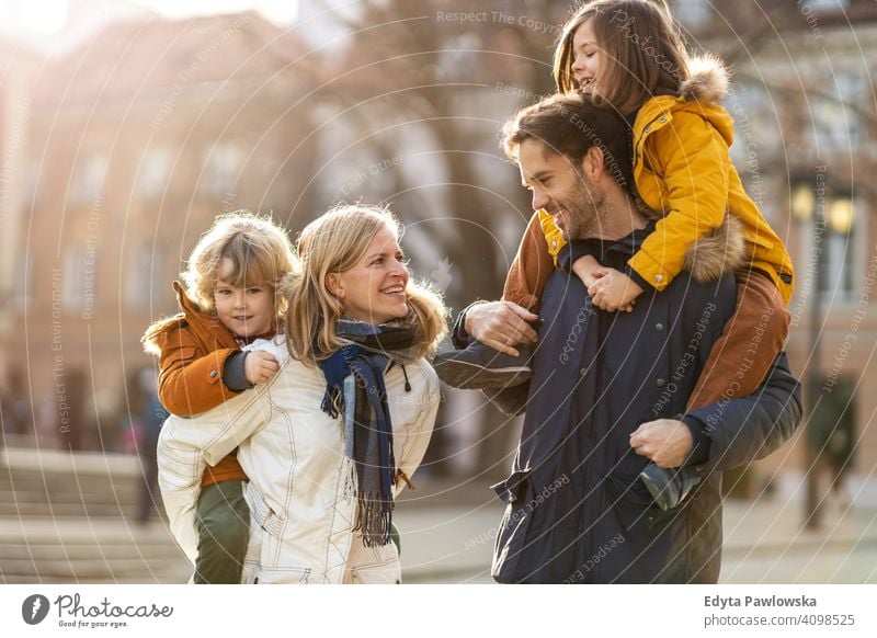 Young family with two children in a city young winter man autumn father woman mother parents relatives son boys kids relationship together togetherness love