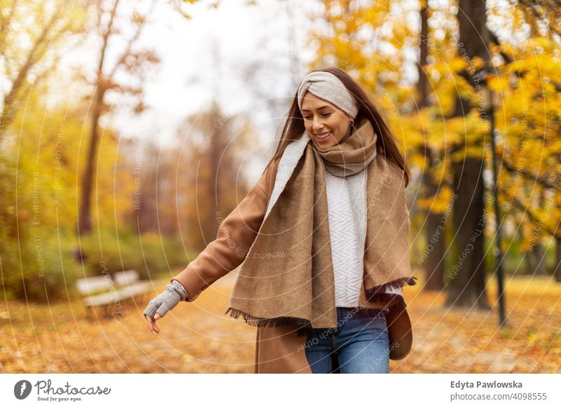 Portrait of smiling young woman in a park in autumn nature leaves freedom healthy trees yellow forest season public park relax serene tranquil fall outdoors