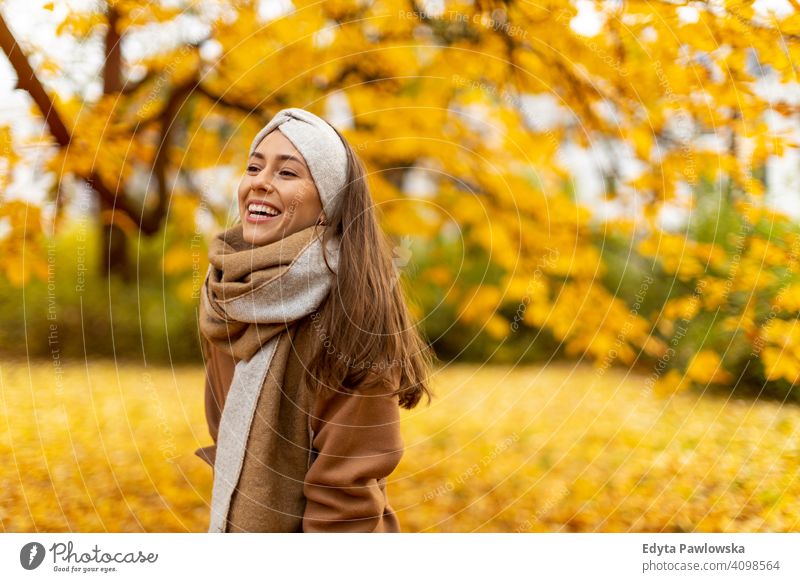 Portrait of smiling young woman in a park in autumn nature leaves freedom healthy trees yellow forest season public park relax serene tranquil fall outdoors