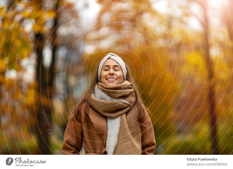 Portrait of smiling young woman in a park in autumn nature leaves freedom healthy trees yellow forest season public park relax serene tranquil fall outdoors