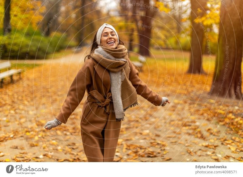 Portrait of smiling young woman in a park in autumn nature leaves freedom healthy trees yellow forest season public park relax serene tranquil fall outdoors