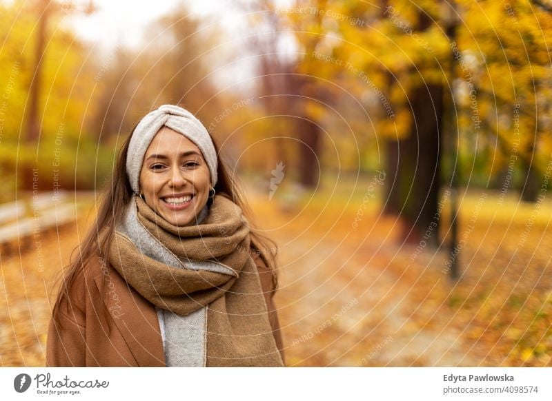 Portrait of smiling young woman in a park in autumn nature leaves freedom healthy trees yellow forest season public park relax serene tranquil fall outdoors