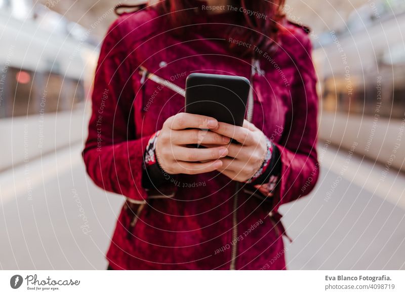 close up of beautiful caucasian woman in train station ready to travel using mobile phone. Travel and lifestyle concept technology smart phone internet device