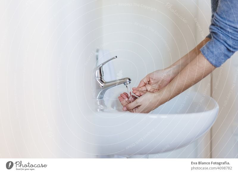 Closeup of caucasian woman washing hands in bathroom to prevent Covid-19 viral infection. Recommended washing with soap and running water during coronavirus pandemic