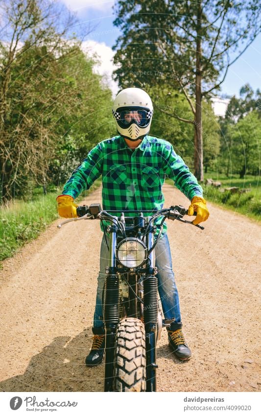 Man with helmet riding custom motorbike man biker defiant vintage retro rider vehicle transport motorcycle posing young adult one people person real