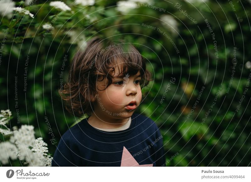 Portrait of a cute girl Child 1 - 3 years Caucasian Girl Foliage plant foliage Spring Green Garden Plant Day Human being Exterior shot Colour photo Nature