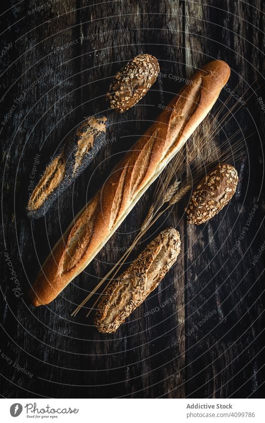 Assorted gold homemade bread on dark wood background food bakery wheat breakfast knolling organic rustic assortment tasty from above flat lay bake natural