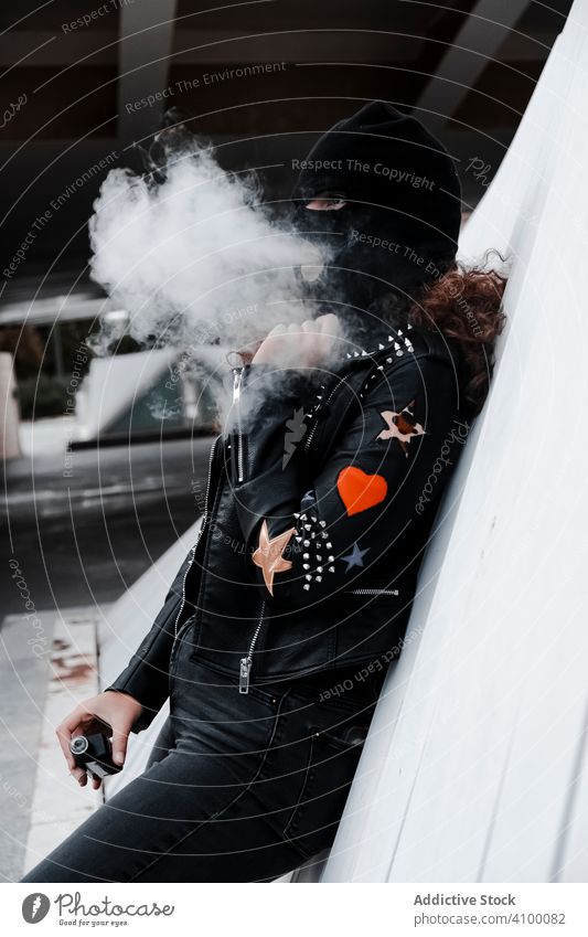 Woman in black mask and jacket smoking on street woman balaclava leather rock urban style stripes brunette fashion city outfit young female underground clothes