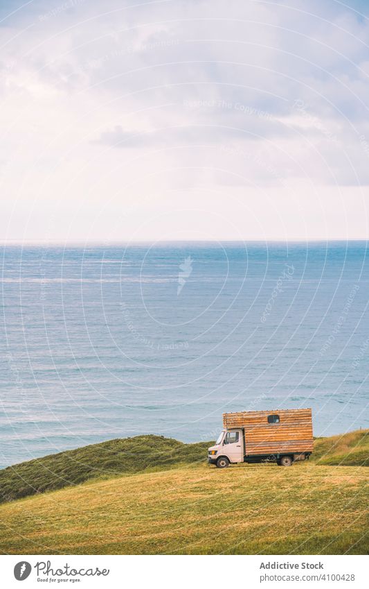 Landscape of empty meadow with passing truck near seaside landscape field cargo hill sky nature scenery countryside water travel tourism environment summer