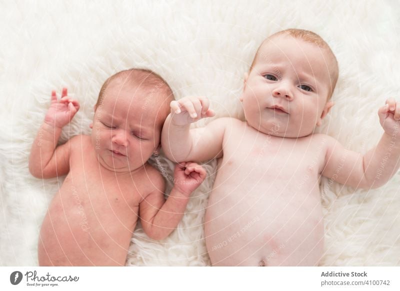 Tender small babies resting on bed at home infant baby newborn lying relax together tiny tender plaid child little adorable care kid sibling sweet love