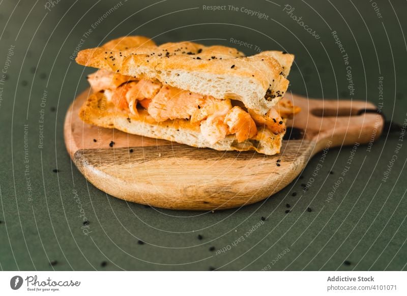 Flat bread sandwich on wooden cutting board sesame flat black round chicken snack food nutrition fresh meal lunch brunch delicious ingredient appetizer