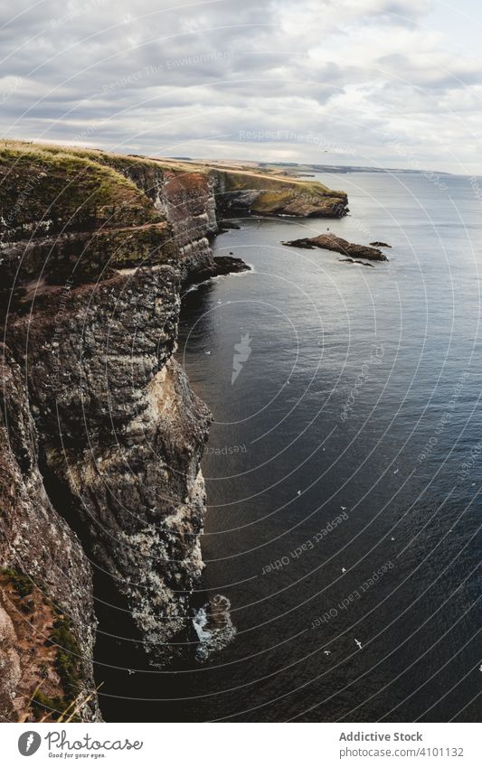 Rocky coast among tranquil ocean water in sunny day sea adventure height headland trip coastline cliff fresh freedom road solitude marine endless shore scotland