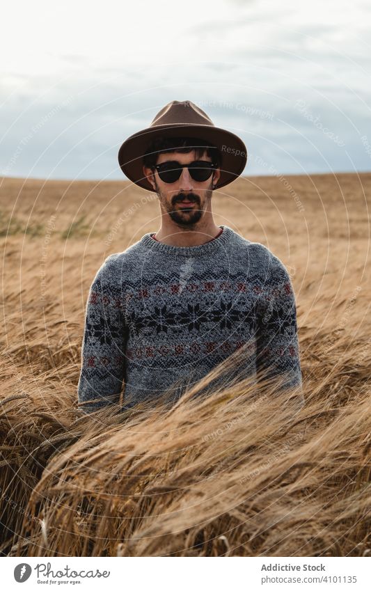 Man standing on dry field and looking at camera man walking farm summer nature sunny daytime young rural rustic agriculture seedlings saplings countryside