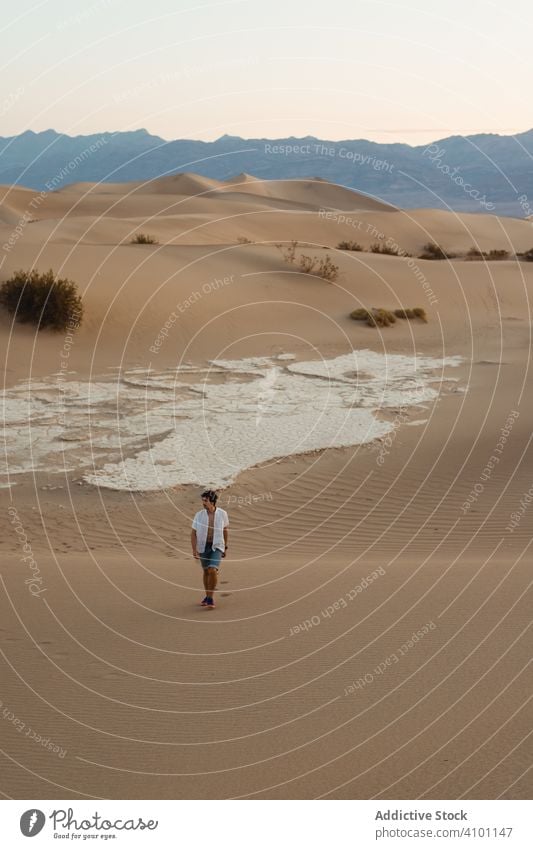 Lonely man walking in sandy desert death valley wanderlust dunes travel vacation direction holiday summer freedom land tourism scenery destination natural dry