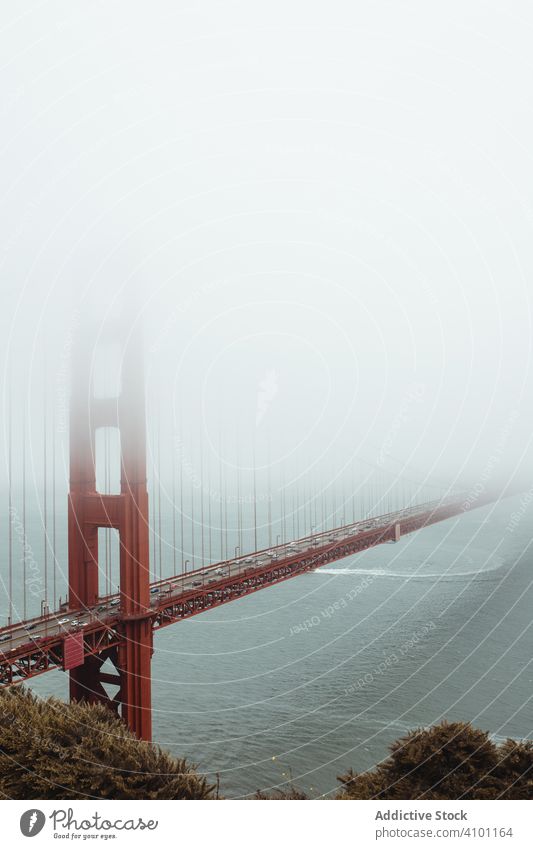 Red bridge construction over wavy dark water shore structure architecture rocky landscape stone sea mountain ocean travel island nature golden gate