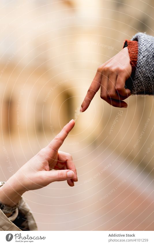 Multiracial women connecting fingers in street in sunny day friendship together stretching content multiethnic multiracial female confident adult trendy