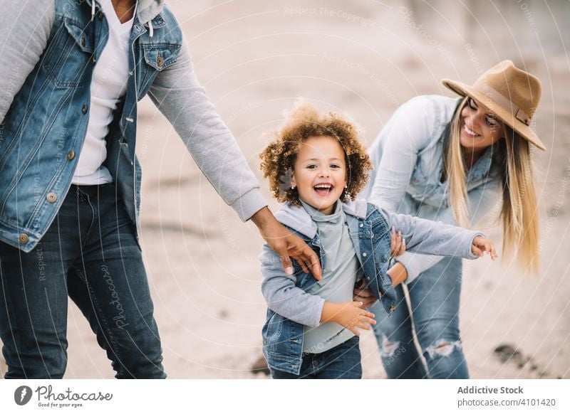 Happy multiethnic family gathering on nature fun parent toddler play rest sand smile happy cheerful lifestyle modern child man bonding love tender casual kid