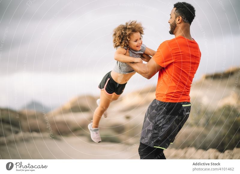 Black father holding child in arms toddler carry sportive smile play fun rest parent happy cheerful lifestyle modern nature man bonding love tender casual kid