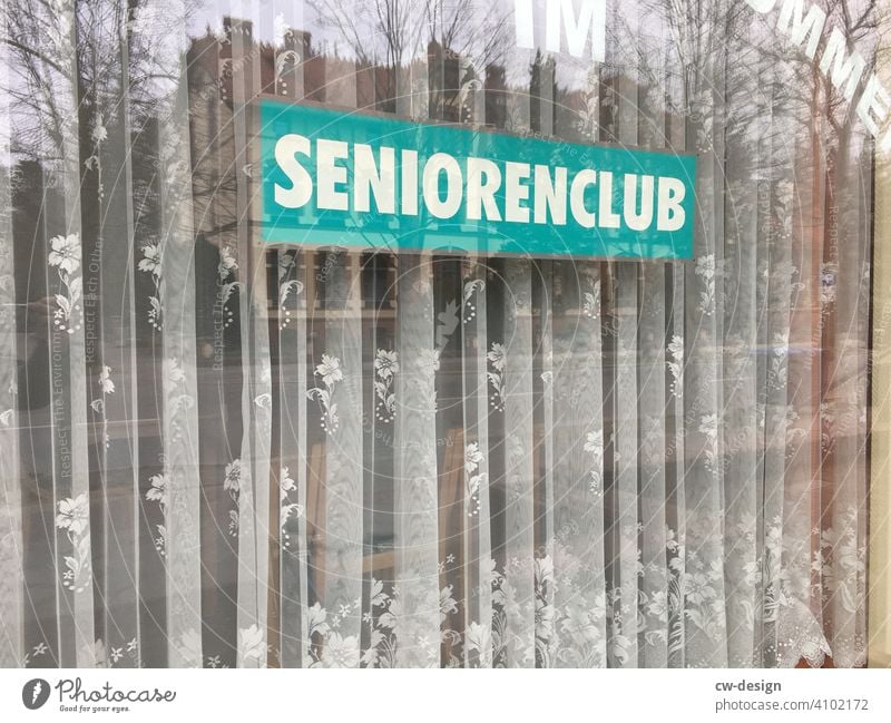 Sign from ˋSeniors Clubˋwith curtain in shop window Senior Citizens Club Curtain Shop window Store premises window display window dressing Shop window facade