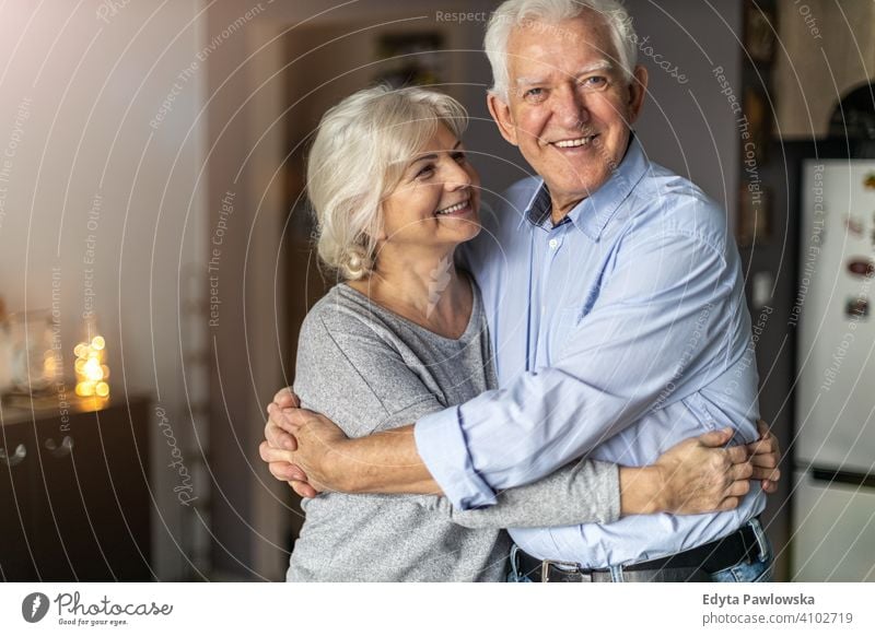 Happy senior couple embracing in their home woman love people together two mature pensioners togetherness retiree retired retirement old marriage healthy