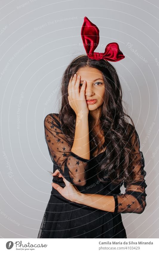 Young woman with black dress and red bow in her hair. Fashion photography. Autumn / winter fashion. Hair accessory. beautiful beauty blogger elegance face