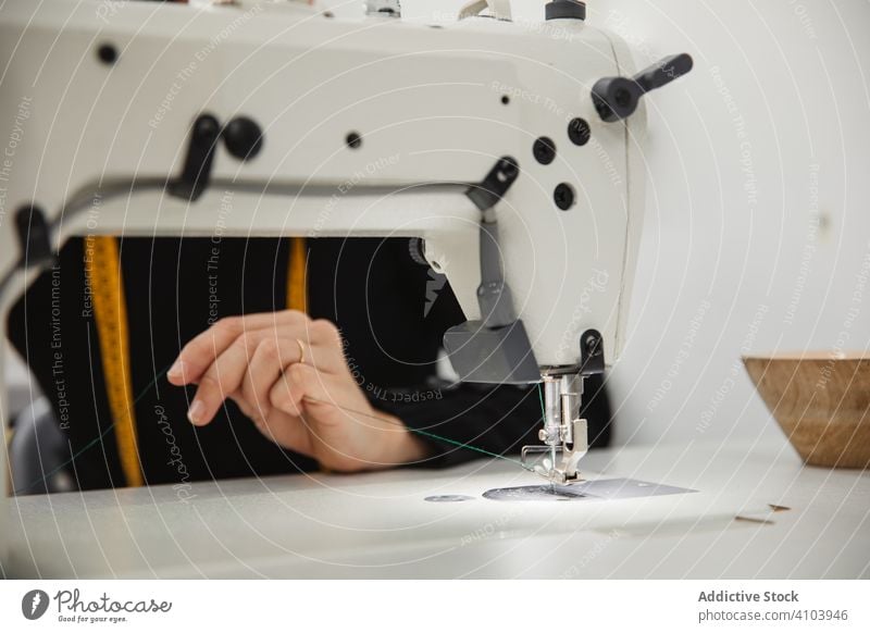 Seamstress using sewing machine in workshop seamstress woman fabric craft occupation material clothing female adult tailor part element detail professional