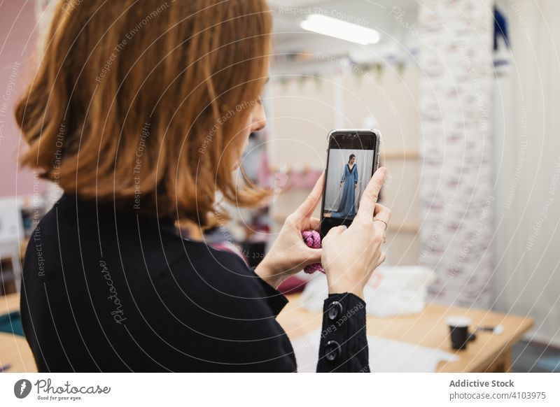 Crop dressmaker taking photo of model in gown workshop take photo portfolio smartphone designer fashion custom women tailor atelier device gadget shot capture