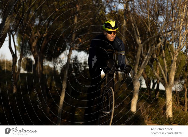 Man cycling in a park race freedom helmet ride speed bicycle bike cyclist exercise fast fitness man person sport adventure healthy lifestyle nature road urban