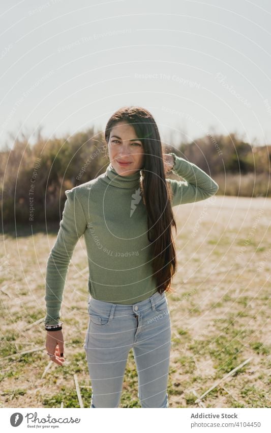 Pensive ethnic woman standing in countryside pensive thoughtful lifestyle think solution serious female casual imagination decision dilemma nature grass day