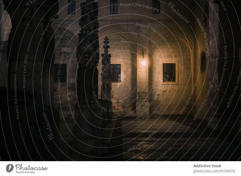 Yard of ancient church at night cathedral courtyard dim cross fence architecture burgos spain building landmark historic heritage old aged antique wall stone