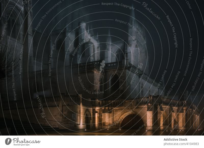 Illuminated wall around aged cathedral at hazy night ancient mist illumination architecture old burgos spain building church historic heritage religion facade