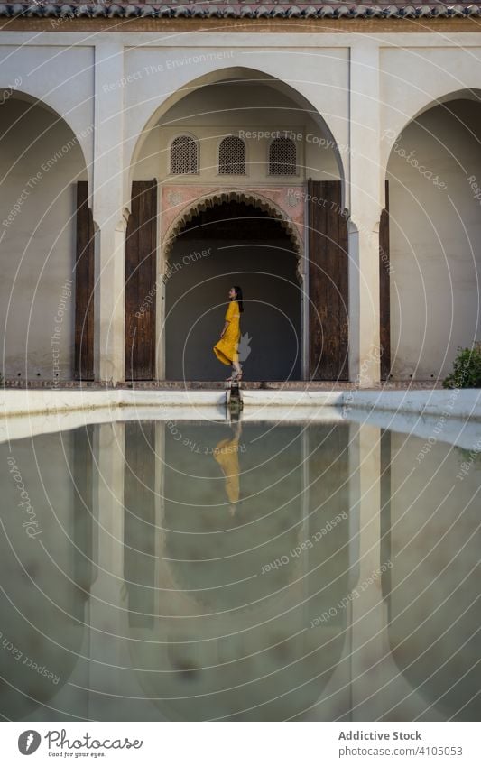 Female tourist near calm pool woman yard arabic old building alcazaba malaga spain female water tranquil serene peaceful exterior fortress palace aged ancient