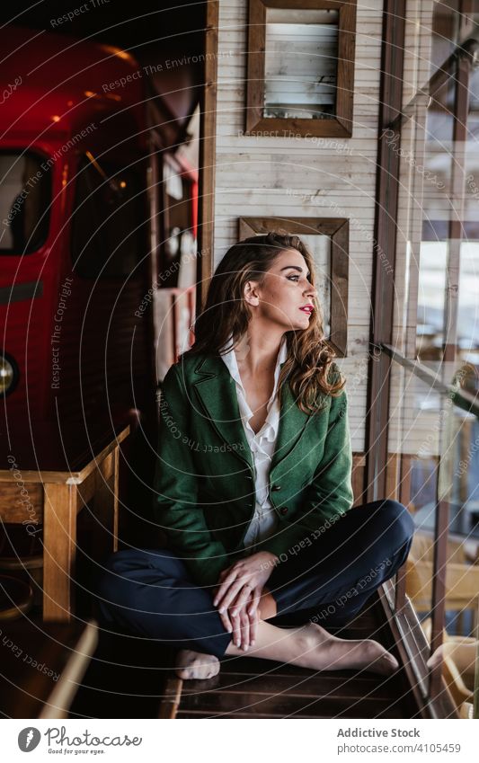 Thoughtful woman in stylish outfit in cafe fashionable trendy young casual lady female model wear clothes elegant charming accessories chic cafeteria lifestyle