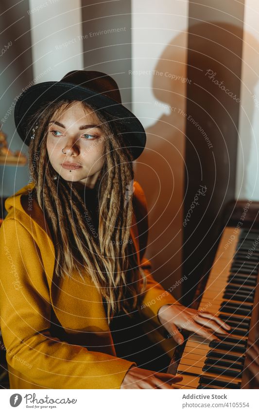 Hipster millennial woman playing piano dreadlocks hipster music stylish serious sit female focused concentrated practicing musician instrument art pianist