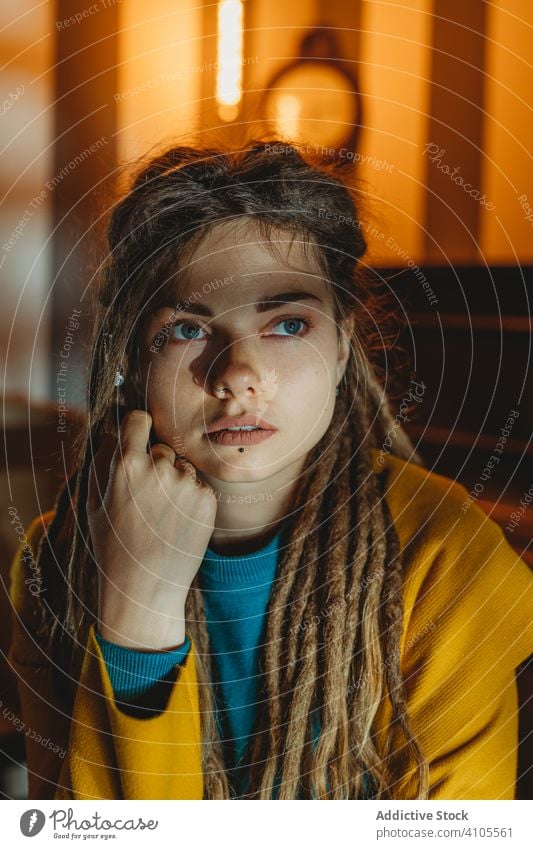 Pensive hipster woman looking away pensive thoughtful young millennial modern dreadlocks serious sit stylish style fashion female portrait think dream casual