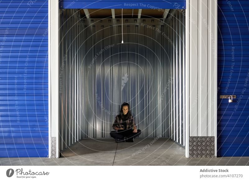 Woman sitting at self storage floor woman package warehouse packing cargo delivery transportation move work relocating packet moving unpacking business