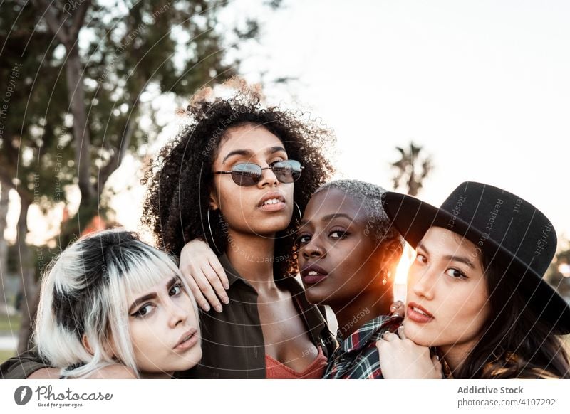 Multiethnic group of female hipsters cuddling with each one women young style smile hug portrait together friend diverse multiracial multiethnic hugging