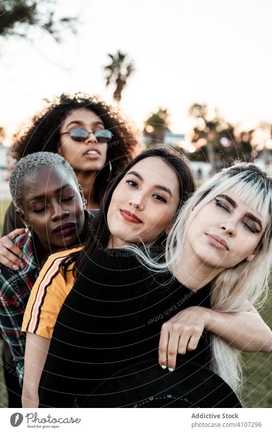 Multiethnic group of female hipsters cuddling with each one women young style smile hug portrait together friend diverse multiracial multiethnic hugging