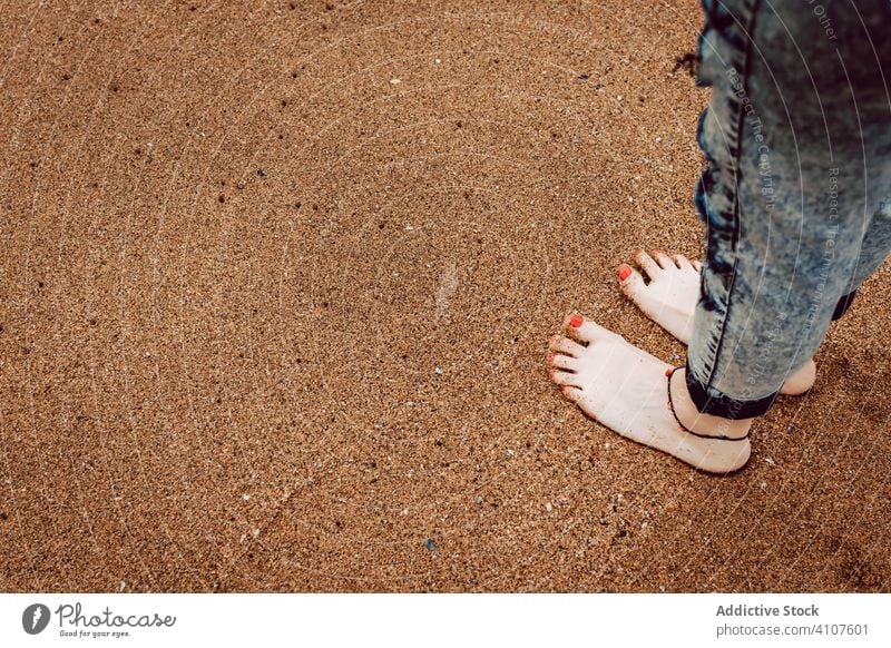 Woman dressed in jeans standing on beach woman barefoot barefooted hipster sea sand stormy wear female style personality ocean water nature travel coast seaside