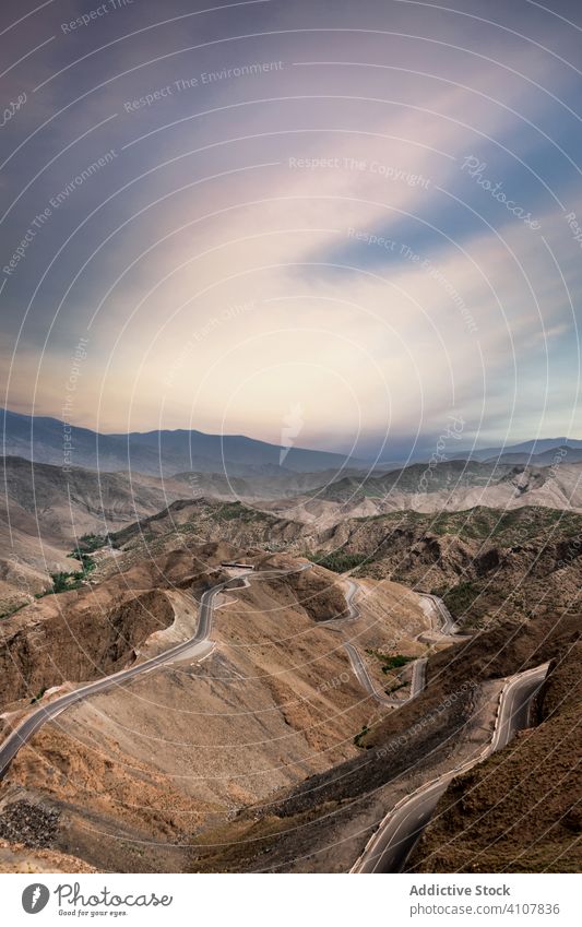 Majestic landscape of empty roads on cliffs route mountain serpentine sky desert terrain remote colorful cloud nature valley rock picturesque travel tourism