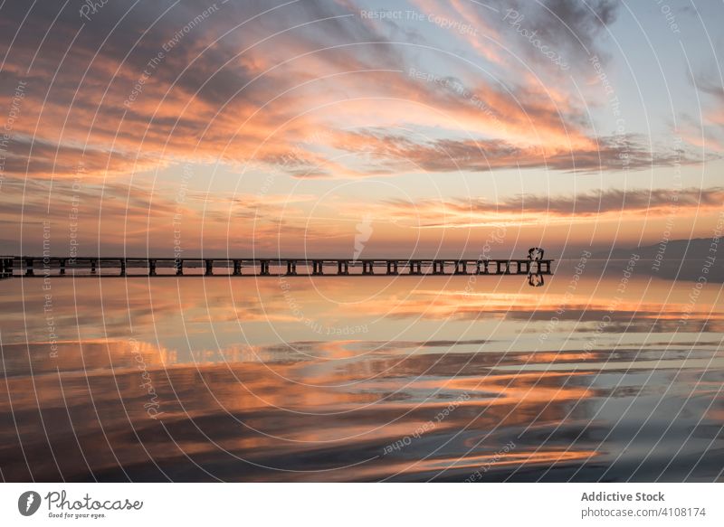 Anonymous tourists standing on pier during sundown ocean sunset water sky nature sea coast travel landscape tourism breathtaking vacation tropical shore scenic