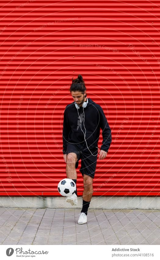 Man playing soccer ball on street man training feint kick football sport activity game energy urban motion healthy lifestyle guy sportsman summer sportswear