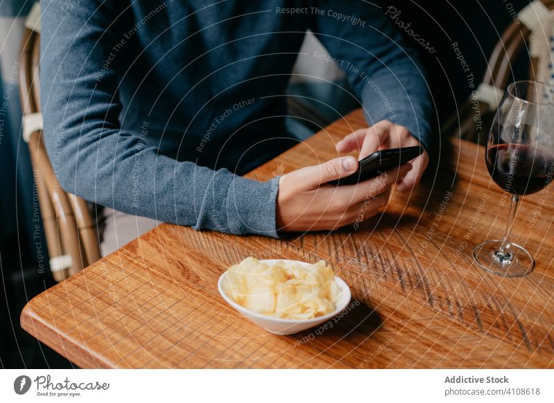 Man using smartphone in cafe man table wine drink rest relax male beverage restaurant casual device gadget surfing modern lifestyle mobile social media browsing