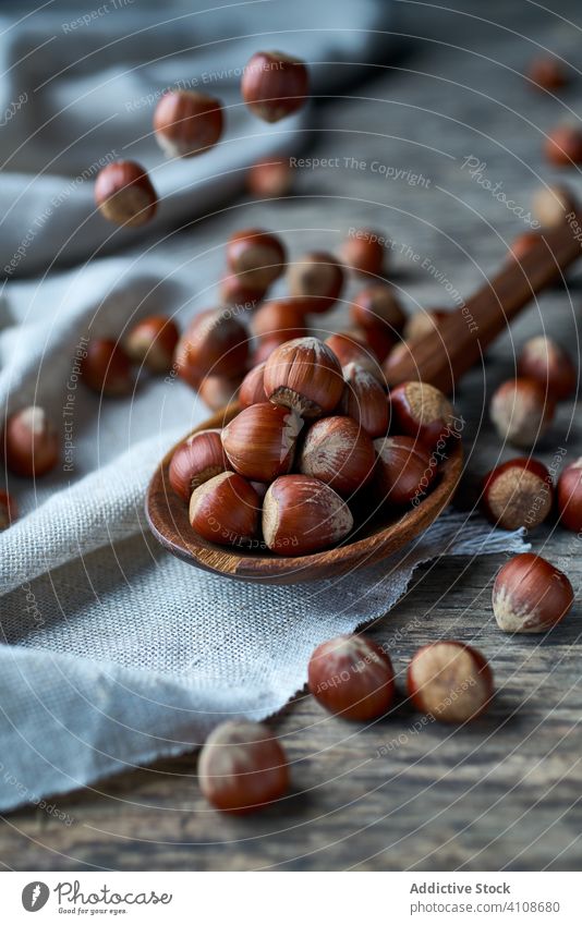 Brown ripe hazelnut on spoon at table brown healthy edible wooden filbert gathering heap ingredient natural harvest organic raw seed food snack linen tasty