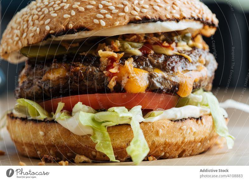 Tasty hamburger on plate in restaurant junk food snack fast food meal tasty lunch patty cutlet lettuce tomato cheese cucumber bun sesame calorie portion dish