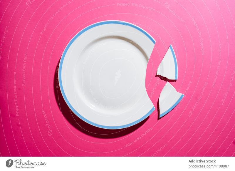 Broken white plate on pink background broken crack crockery crush fragment shard piece tableware porcelain ceramic board clean empty concept accident dish