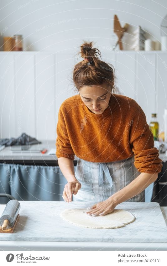 Cook kneading dough with hand on table cook rolling pin flour preparation bakery kitchen culinary making apron recipe food homemade prepare raw cuisine