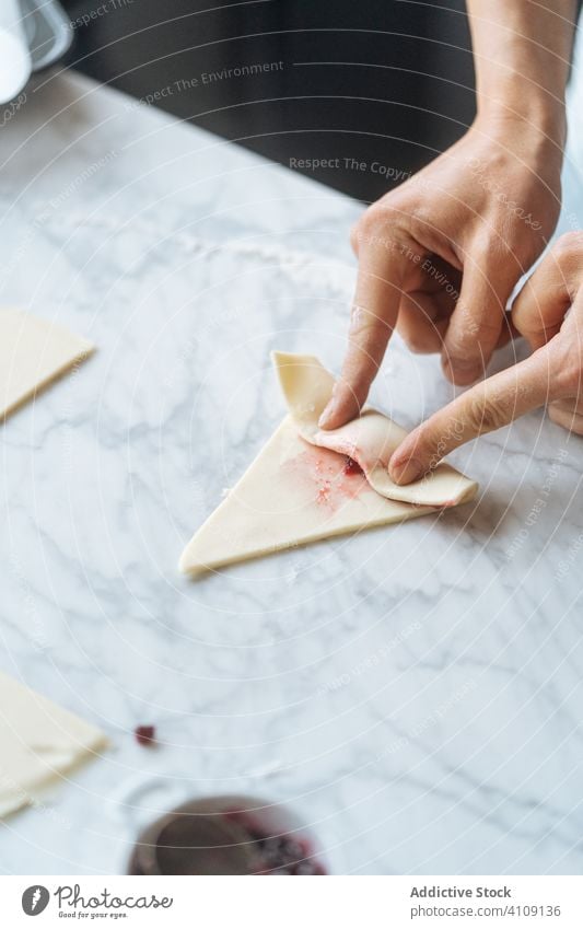 Cook twisting dough into croissant on table cook bagel flour rolling pin preparation sliced bakery homemade culinary making kitchen dessert recipe food raw