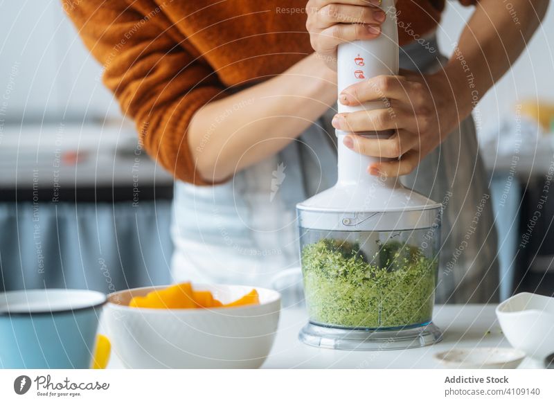 Woman mixing vegetables in blender in kitchen woman cook green cooking fresh vegan vegetarian food health diet sauce ingredient chef preparation cuisine puree