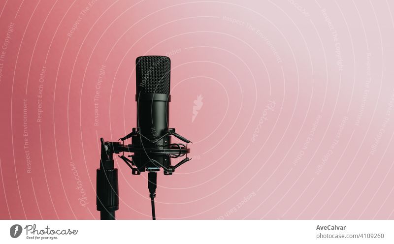 Minimalistic image of a streaming microphone over an pastel pink background with copy space, minimal concept, technology streaming mockup blue streamers